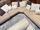 a large sectional couch with pillows on it in a living room