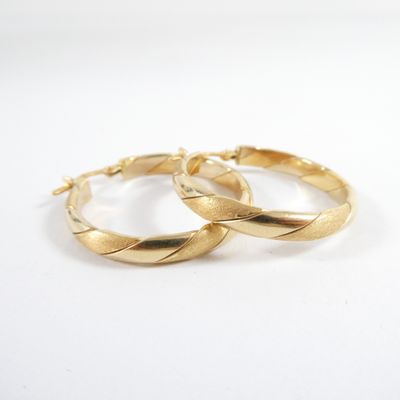 two gold hoop earrings on a white background