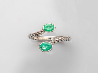 un gros plan d'une bague sertie de deux émeraudes