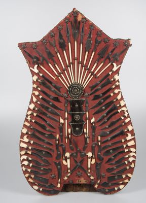 un gros plan d'un vase rouge et blanc orné de couteaux