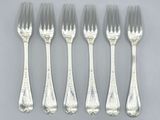six forks and a spoon are lined up on a table