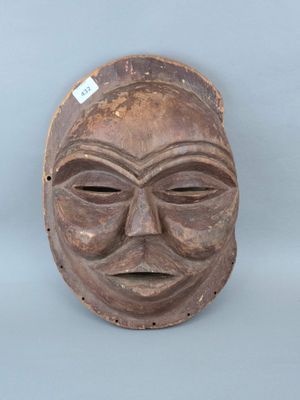 gros plan d'un masque en bois sur une surface blanche