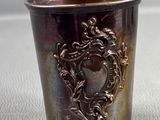 a silver cup with a picture on it sitting on a table