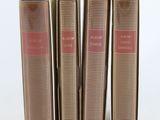three books sitting on top of each other on a white surface