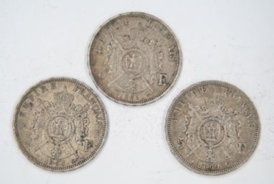 three silver coins sitting on top of a white surface
