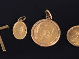 un ensemble composé de trois médailles d'or et d'une croix sur fond noir
