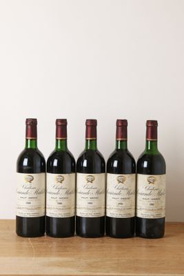 quatre bouteilles de vin sont alignées sur une table en bois
