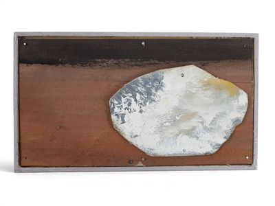 une photo d'un morceau de métal sur lequel repose une pierre