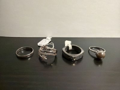 five different rings on a table with a tag on it