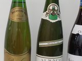 three bottles of wine are lined up on a white surface