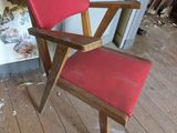 une chaise rouge qui se trouve au milieu d'une pièce