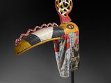 une sculpture en bois représentant un oiseau, posée sur un socle