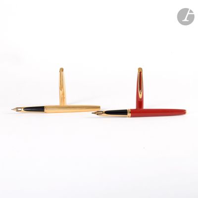 une paire de stylos à bille rouges et dorés sur fond blanc