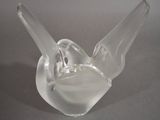 a glass bird that is sitting on top of a plate