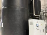 a large black tank sitting next to a white machine