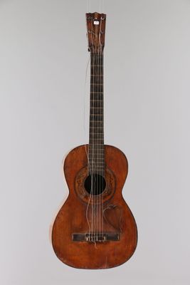 a close up of a guitar hanging on a wall