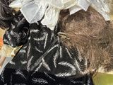 a doll that is wearing a black dress and a white hat
