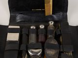une trousse noire contenant une brosse, un peigne et d'autres accessoires