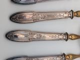 three silver spoons and a fork on a white surface