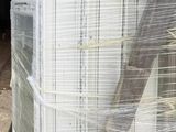 a stack of white refrigerators sitting on a pallet next to a building
