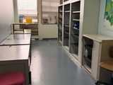 une pièce avec un bureau, des chaises et une carte accrochée au mur