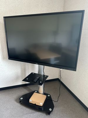 un téléviseur à écran plat sur un support dans le coin d'une pièce
