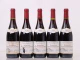 six bouteilles de vin sont alignées sur une table