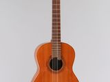 un gros plan d'une guitare acoustique accrochée au mur