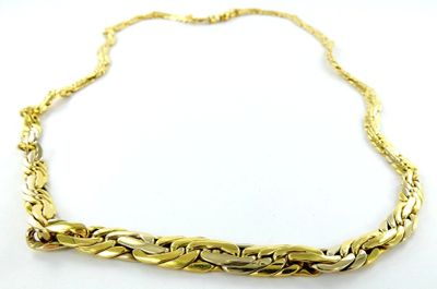 gros plan d'un collier en or sur une surface blanche