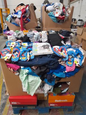 un tas de vêtements posé sur un carton dans un entrepôt