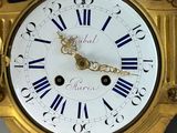 a gold clock with roman numerals on the face