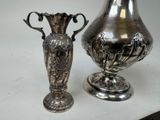 two silver vases sitting on a table next to each other
