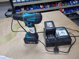 une perceuse filaire et deux batteries posées sur une table