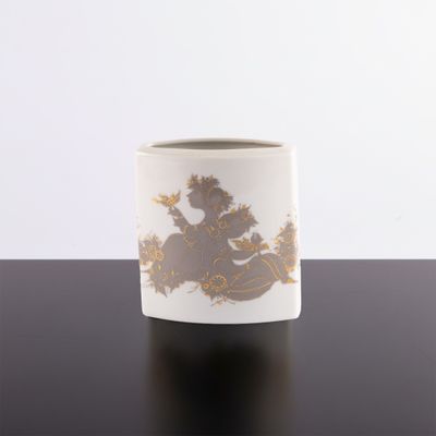 a white cup with gold designs on it on a table