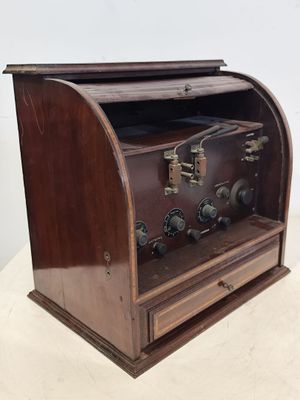 une radio à l'ancienne, avec son boîtier en bois, posée sur une table