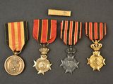 trois médailles et une médaille posée sur une table, avec un bâton en bois