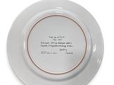 a white plate with a quote on it sitting on top of a table