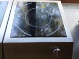 a stove with a glass top sitting in front of a window