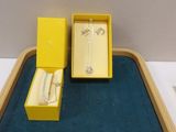 a small tray with a ring and a watch on it