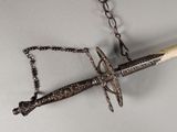 un couteau suspendu à une chaîne au mur