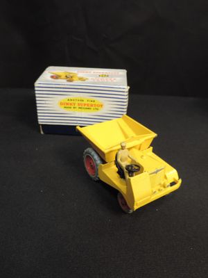 a yellow toy truck that is next to a box of cards