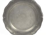 a silver plate on a white table with a white background