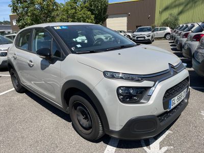 La Citroën blanche est garée sur un parking, à côté d'autres voitures