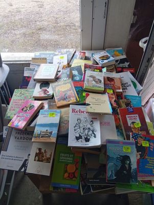 a table full of books on a table in front of a window