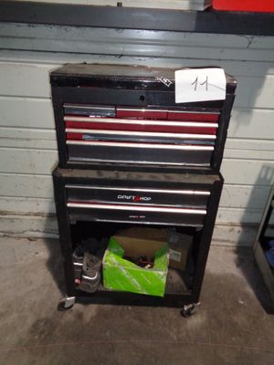 une armoire à outils sur laquelle sont posés des outils, dans un garage