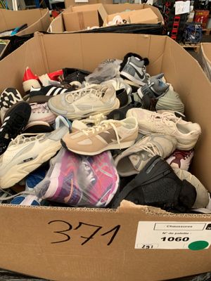 de nombreuses paires de chaussures dans une boîte en carton dans un magasin