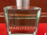 une image représentant un flacon de parfum posé sur une surface rouge