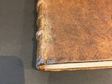 an old book sitting on a table with a shadow of a person