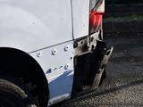 a close up of a white van parked on the side of the road
