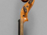 an old violin with a wooden bow on a gray background